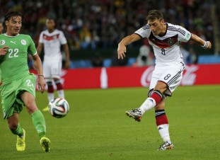 Germany's Ozil attempts a shot on goal past Algeria's Mostefa during their 2014 World Cup round of 16 game at the Beira Rio stadium in Porto Alegre